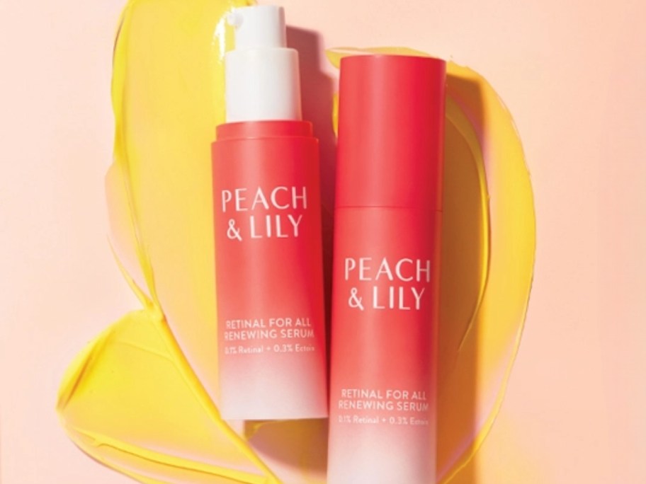 open and closed bottles of Peach & Lily Retinal For All Renewing Serum on top of the yellow serum spread out on a peach background