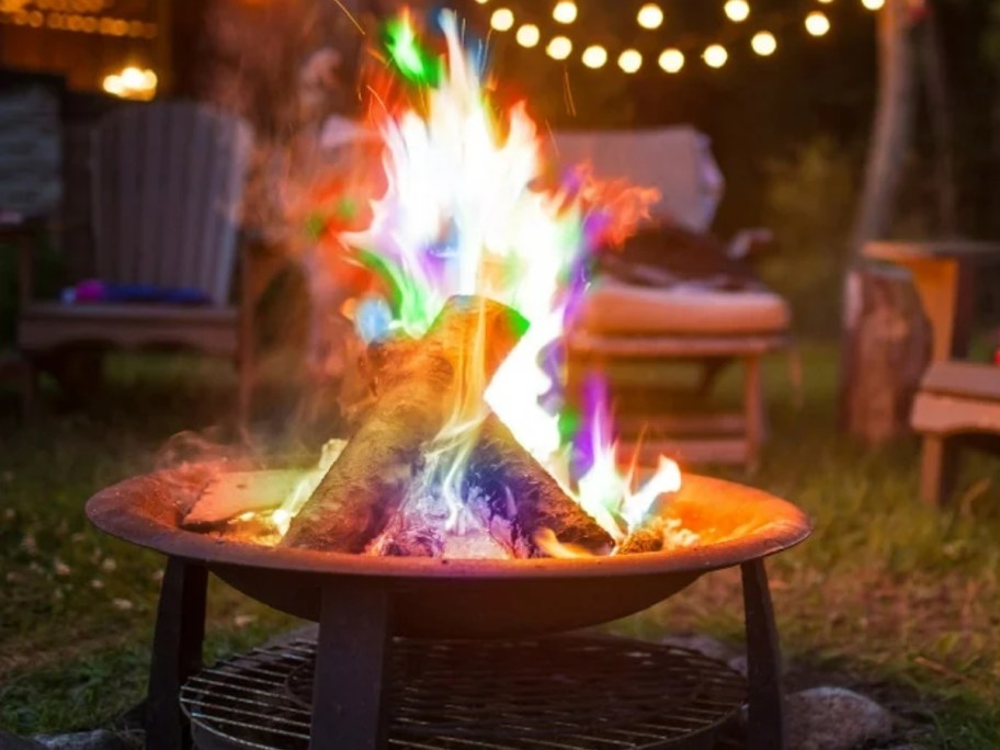 an outdoor firepit with colorful flames
