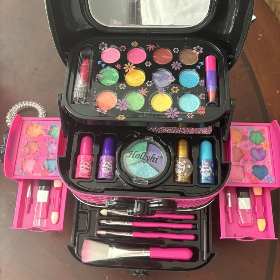 a hot pink and black kid's makeup case kit with onlinepartments open showing all the makeup