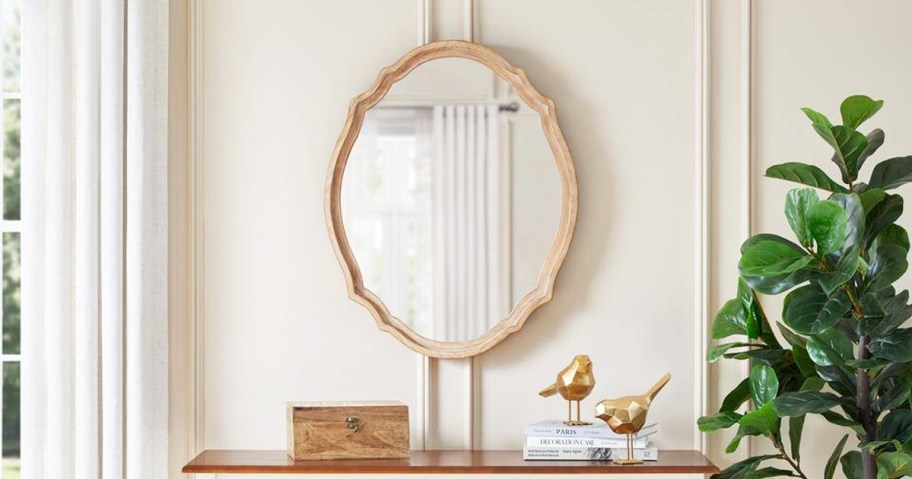 wood framed wall mirror over console table