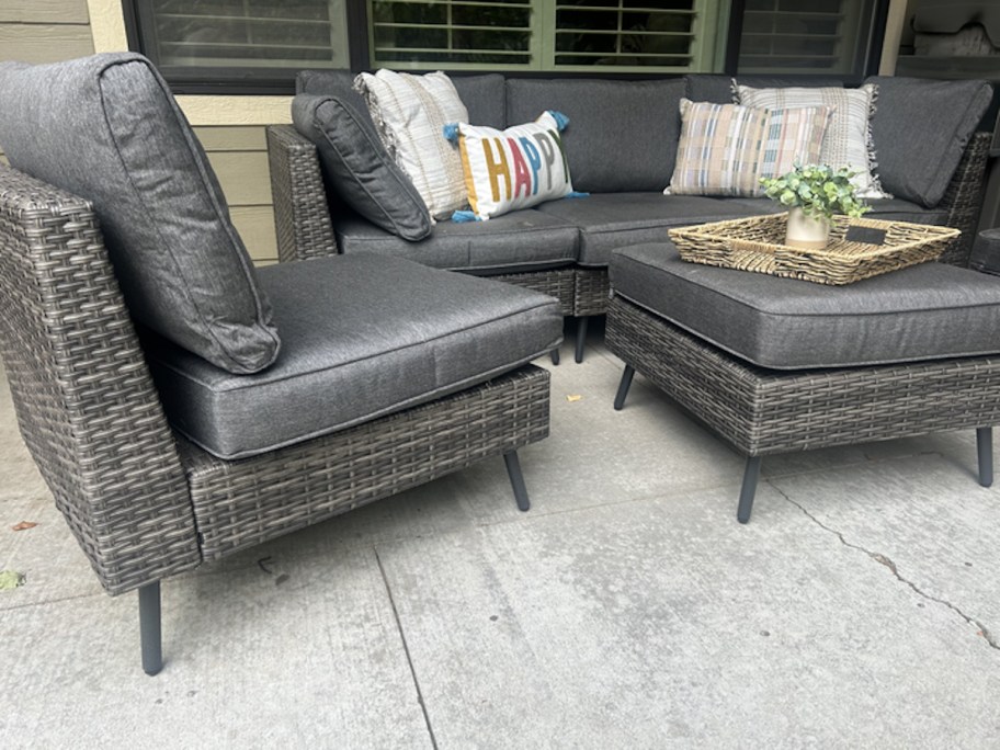 close up of gray wicker patio furniture on concrete patio