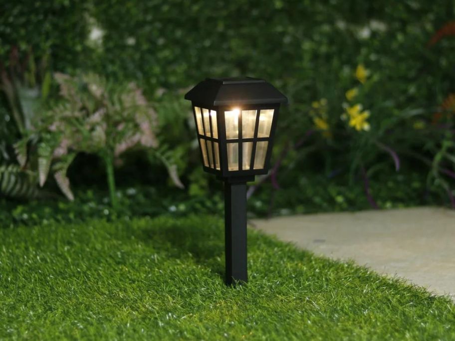 One Mainstays Solar Powered Black Square Design LED Path Light on a lawn