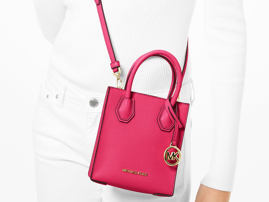 woman in white outfit with a bright pink crossbody bag