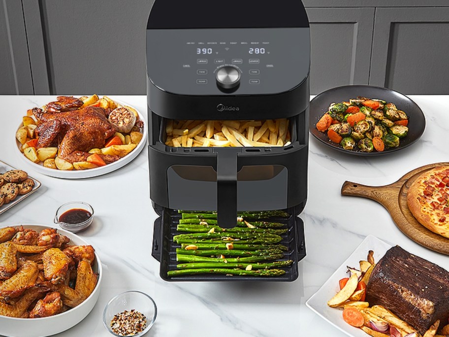 large black 2 basket air fryer oven oven with food inside and more dishes of food around it