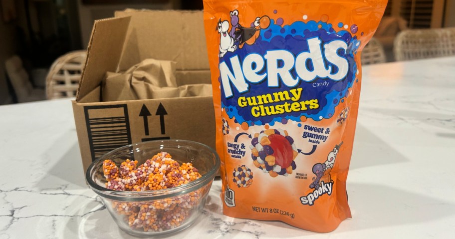 orange bag of Nerds Halloween Gummy Clusters on counter next to Amazon box and bowl of candies