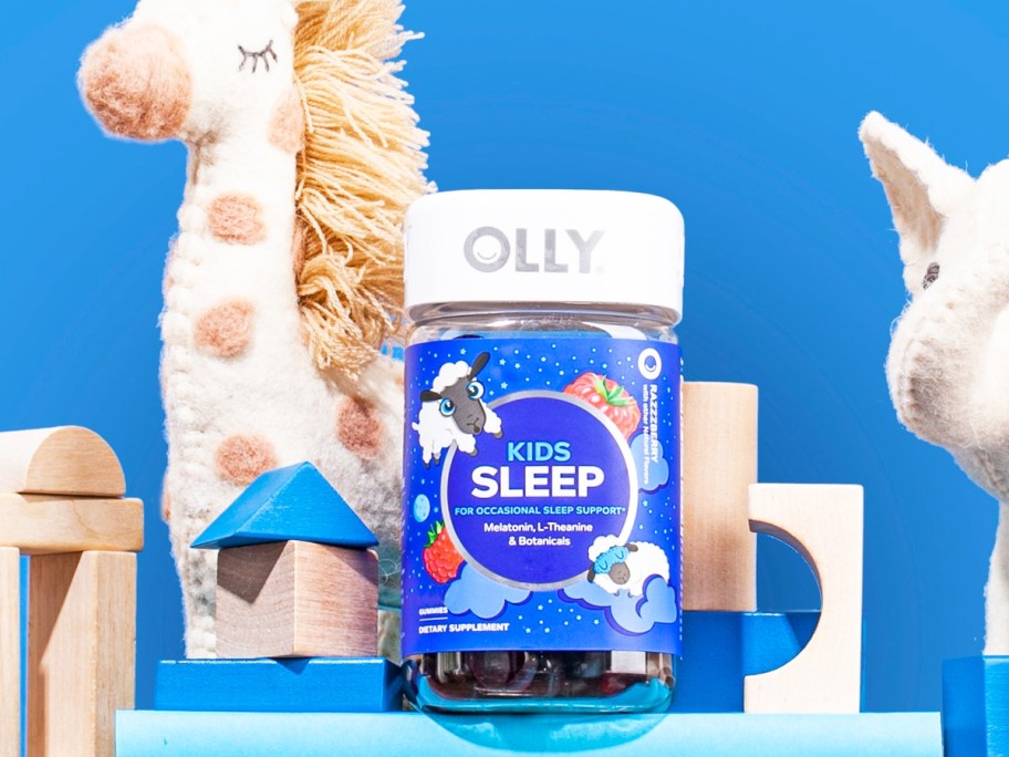 OLLY Kids Sleep Gummy bottle on top of blocks near stuffed animals