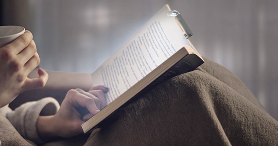 woman reading book with book light