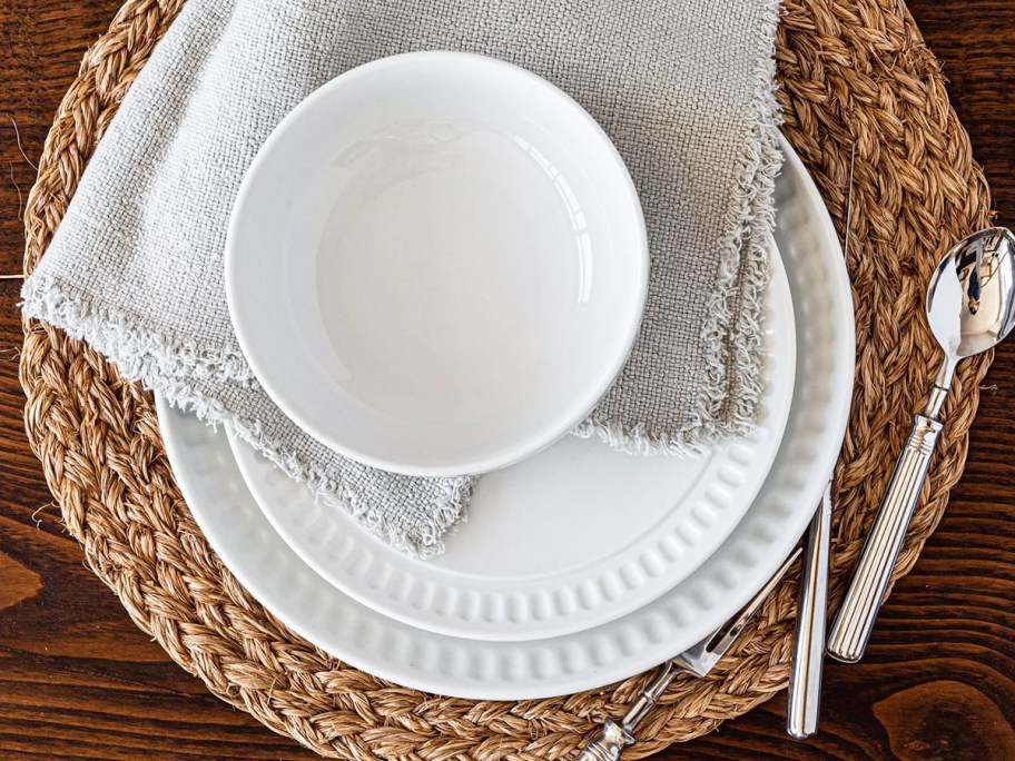 white dinnerware set with silverware, napkin, and placemat