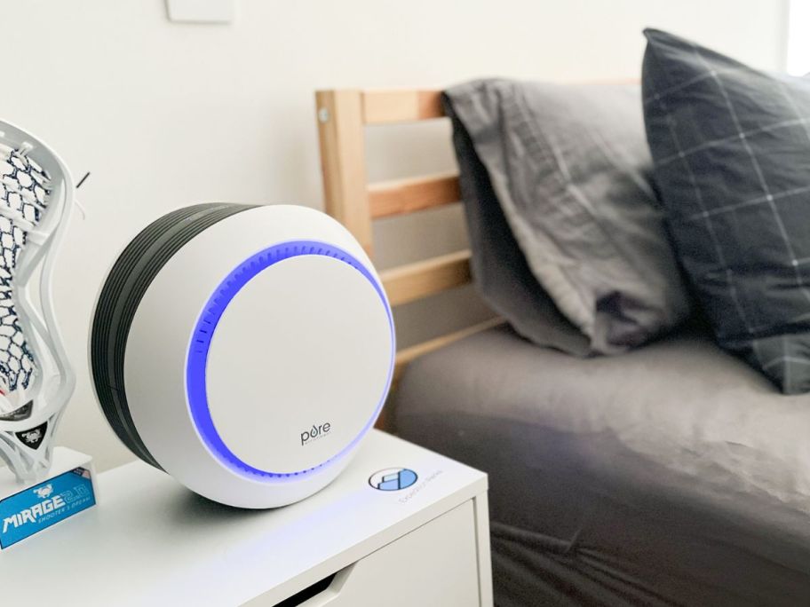 A Pure Enrichment Air purifier next to a child's bed 