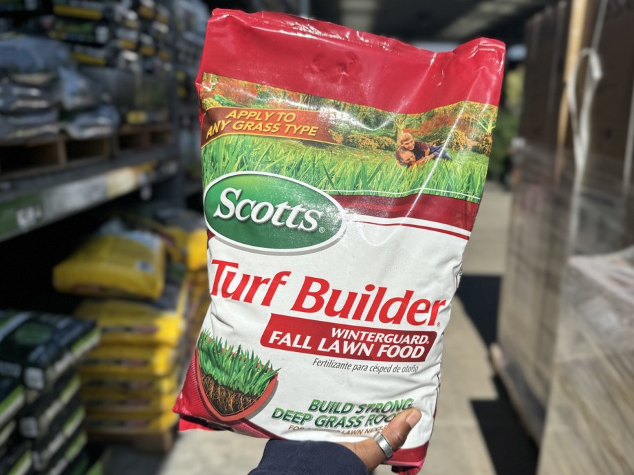 hand holding up white and red bad of Scotts Turf Builder