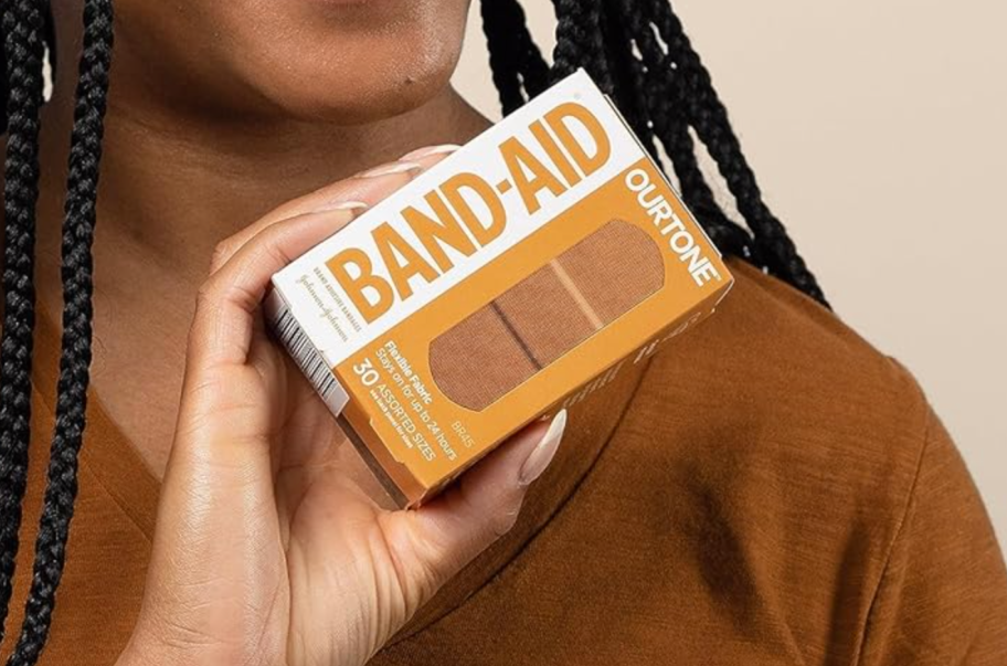 woman holding box of band-aids