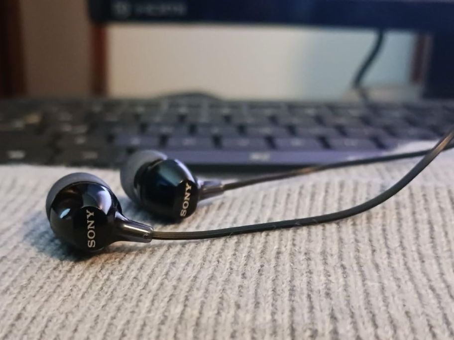 A pair of Sony MDR-EX15LP Earbuds on a blanket