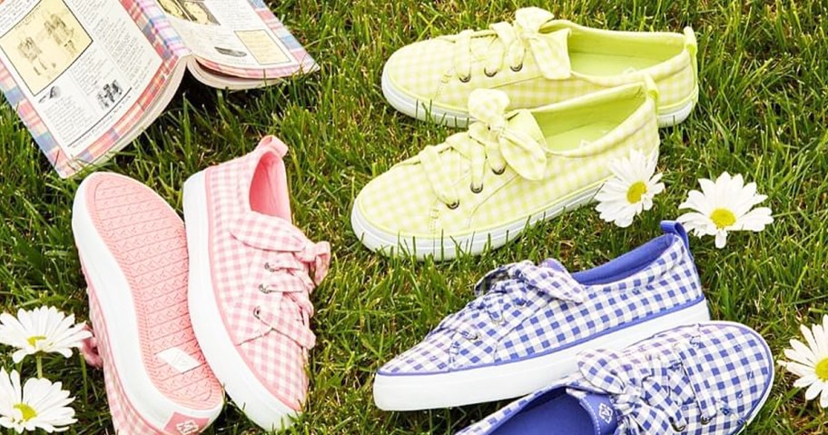 gingham print sneakers in grass with daisies and book