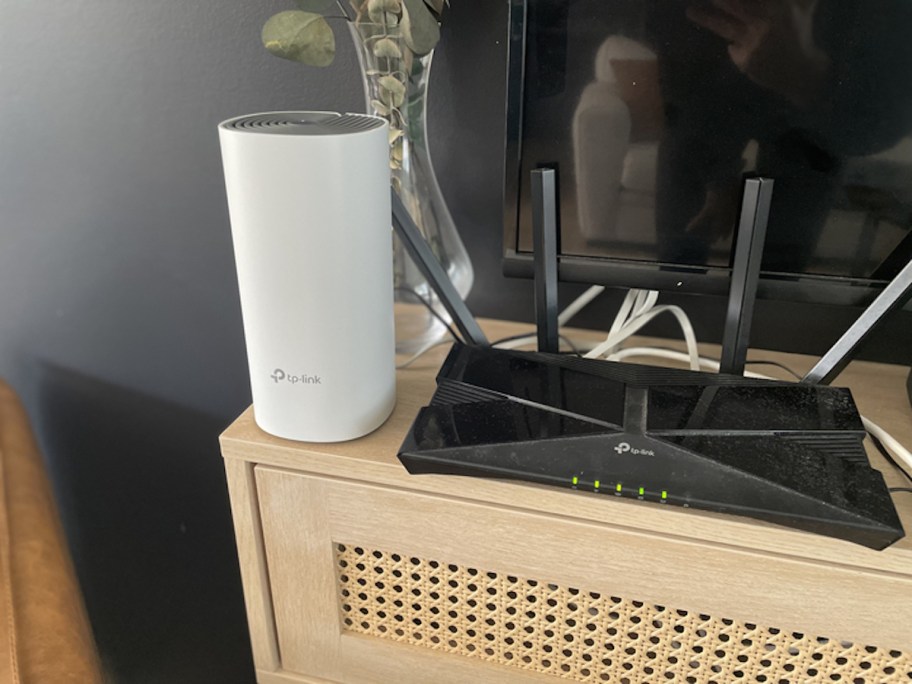 router and extender sitting on top of caned console table