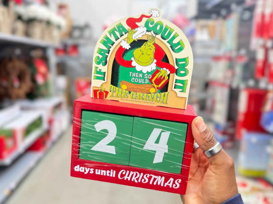 The grinch Christmas countdown in womans hand