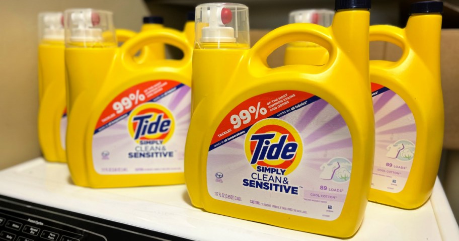 Four huge bottles of tide simply detergent on top of washing machine