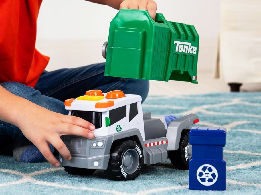 boy playing with a green tonka garbage truck