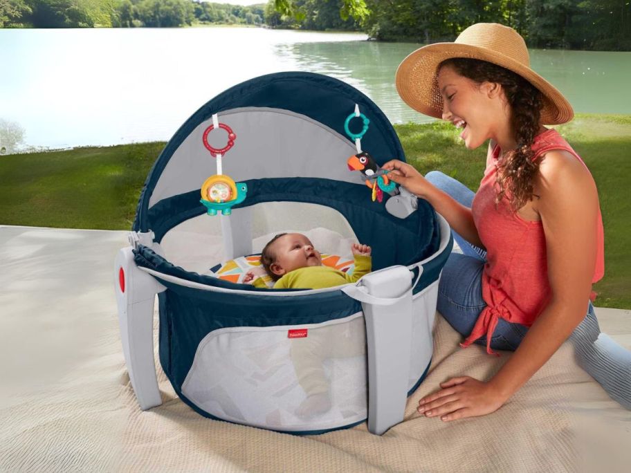 baby in Fisher-Price On-the-Go Baby Dome with woman next to it