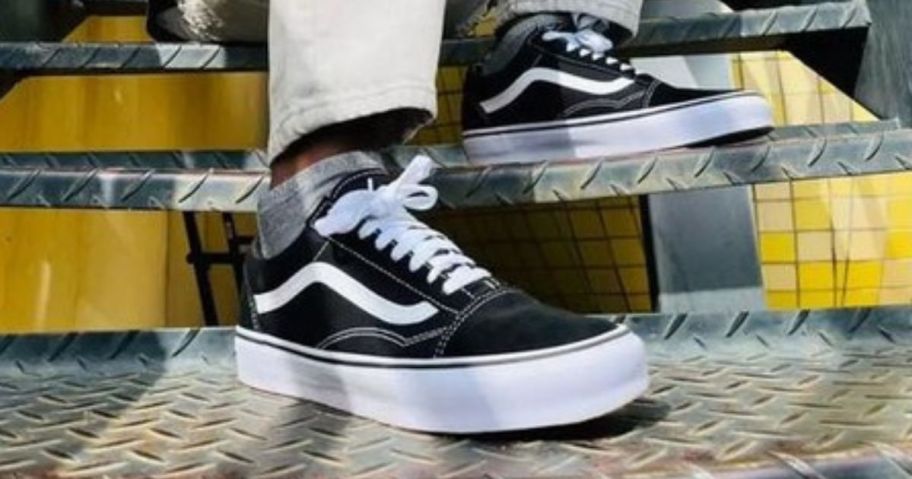 A man wearing a pair of Vans Old Skool Shoes in black and white