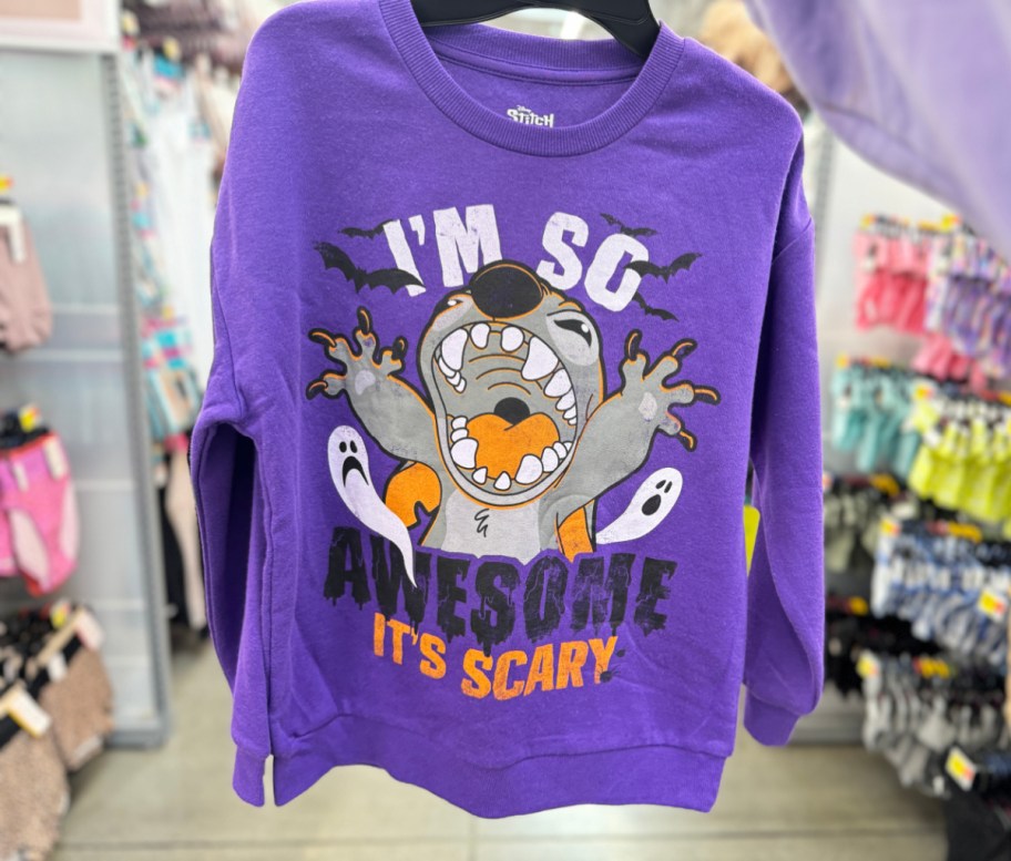 hand holding up a Walmart Halloween Sweatshirt of Disney's Stitch