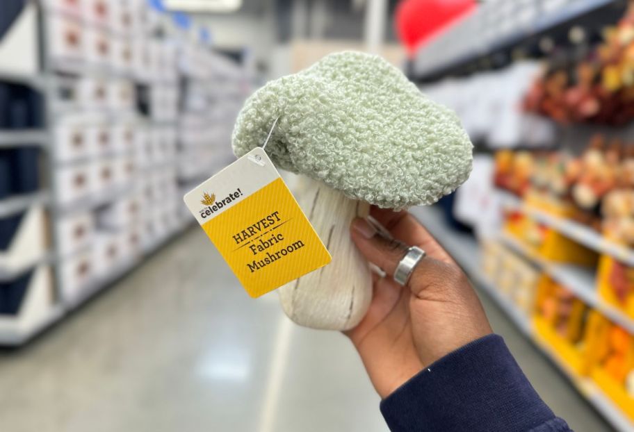 a womans hand holding a green sherpa mushroom