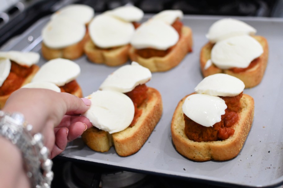 adding fresh mozzarella to meatball subs