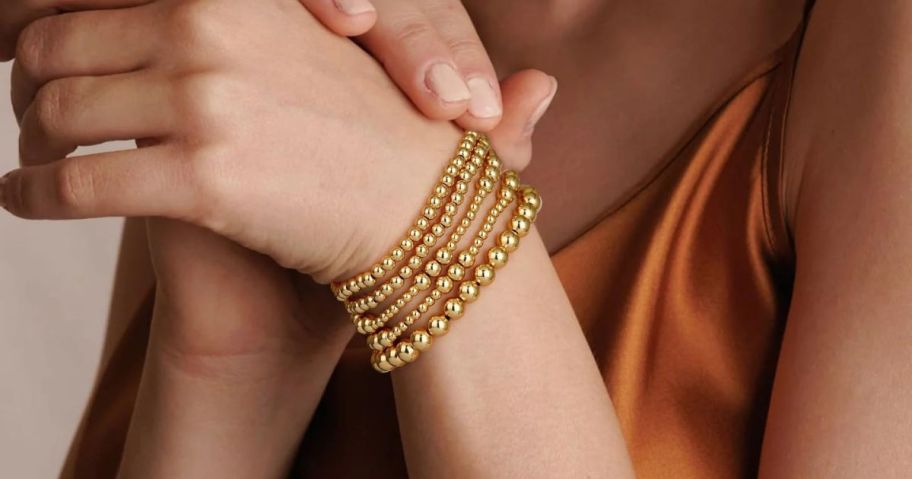 a woman wearing adoyi stackable gold bracelets for women