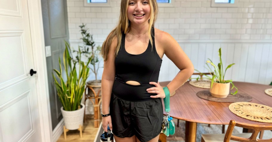 woman wearing black romper holding cup 