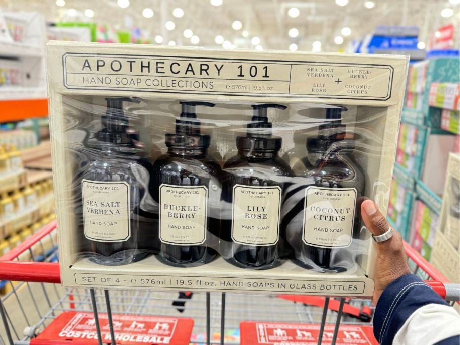 a womans hand holding a 4-pack of hand soaps