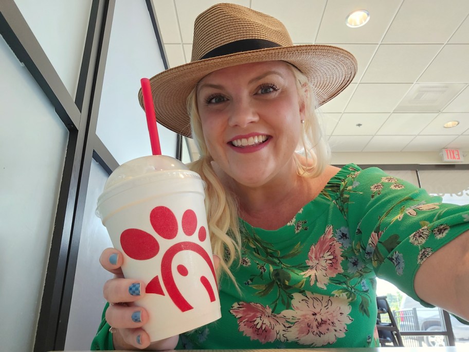 smiling woman holding a chick fil a banana pudding milkshake