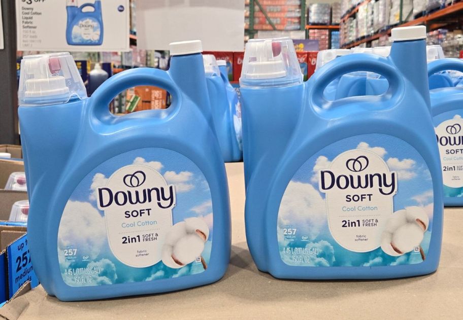 two large jugs of downy fabric softener stacked on a pallet in a Costco warehouse 