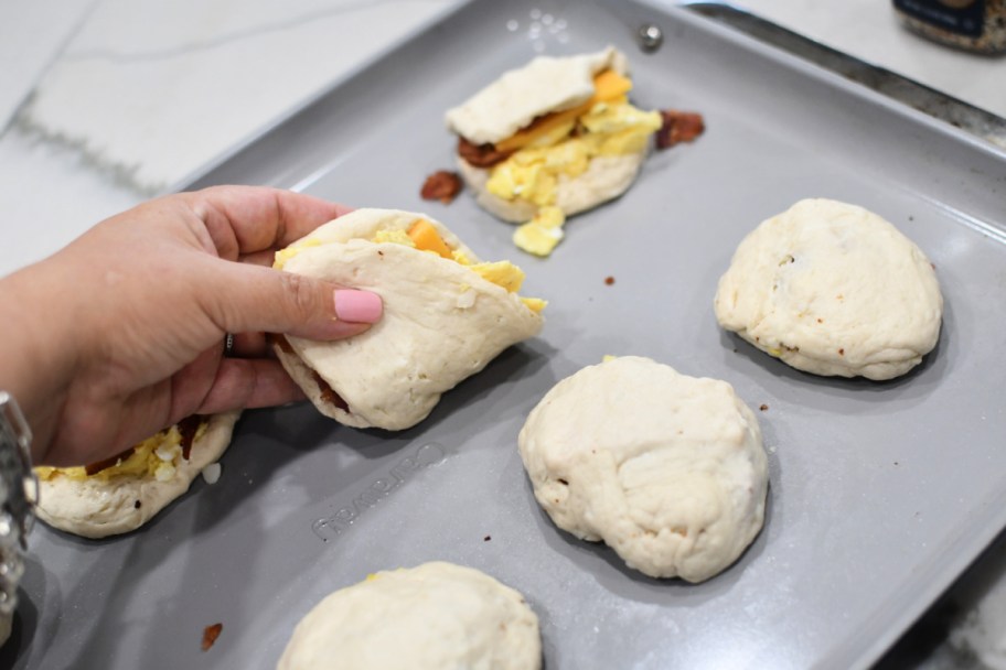 folding breakfast bombs dough on a sheet pan 