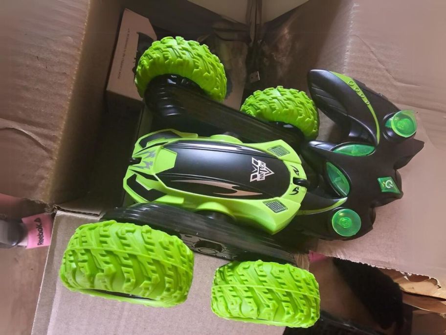 a green double-sided remote control car on a cardboard box