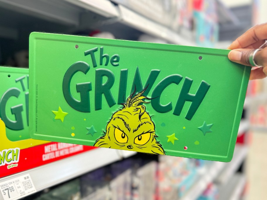 grinch sign being held at the store