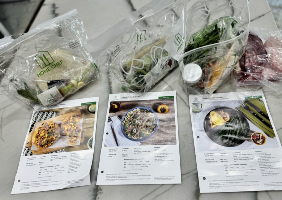 three home chef bags next to recipes