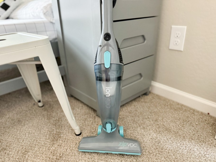 blue and grey stick vacuum in dorm room