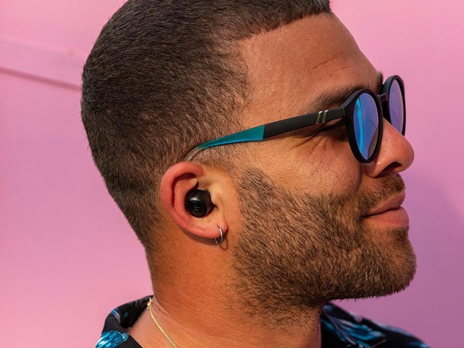 man with black earbud in ear wearing sunglasses 