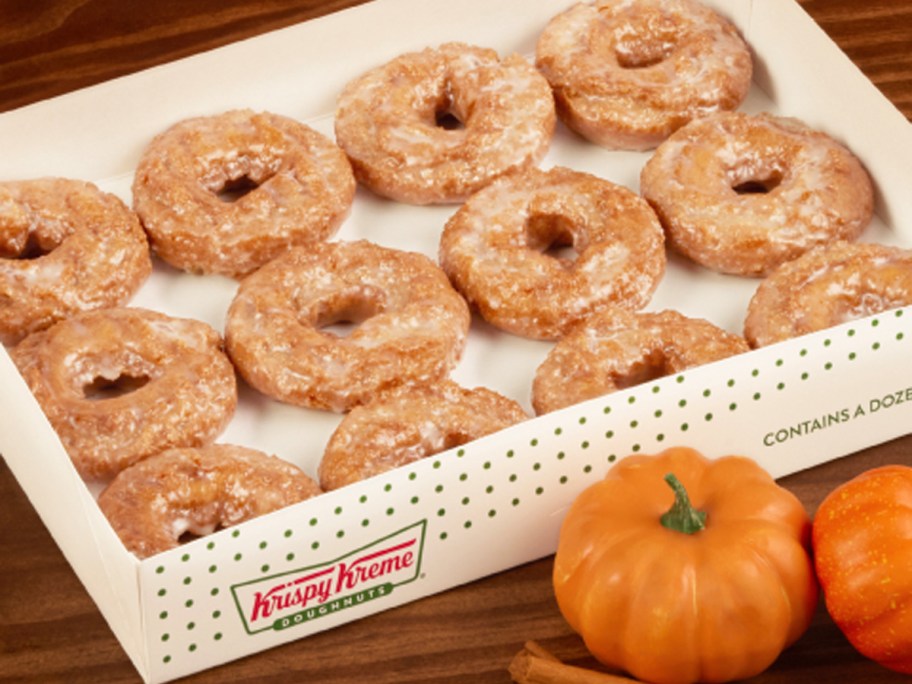 12 count box of pumpkin spice doughnuts next to small pumpkins 