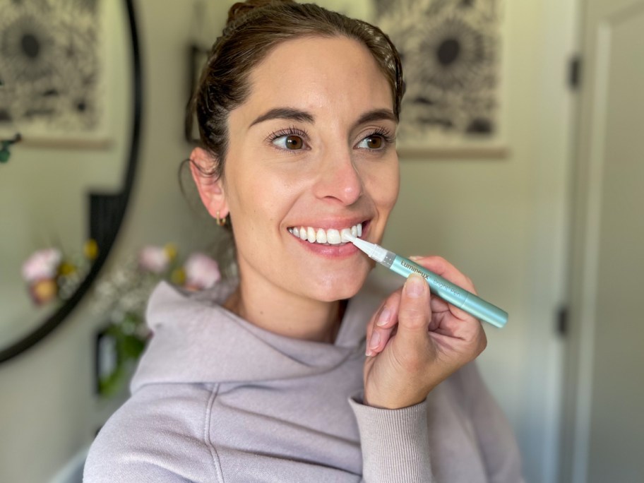 woman using teeth whitening pen