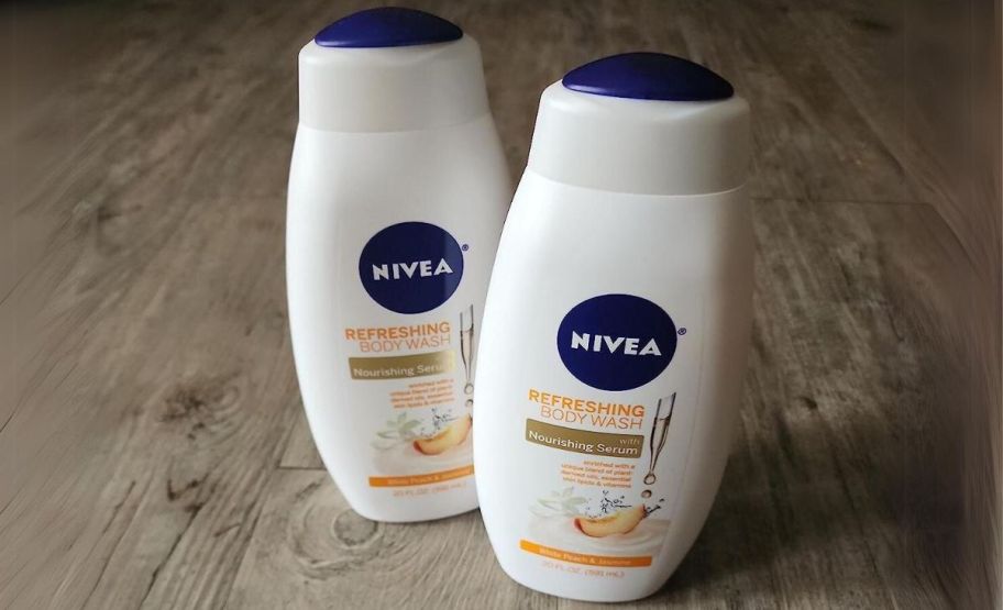 two NIVEA White Peach & Jasmine Body Wash 20oz Bottles on a hardwood floor