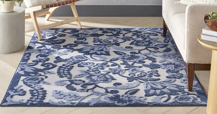 blue and white floral rug next to couch 