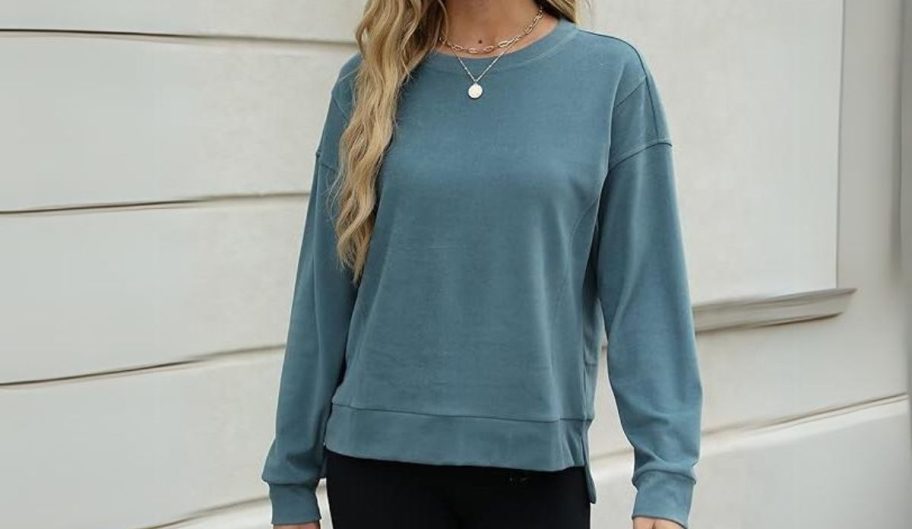 a woman in a blue cropped crewneck sweatshirt