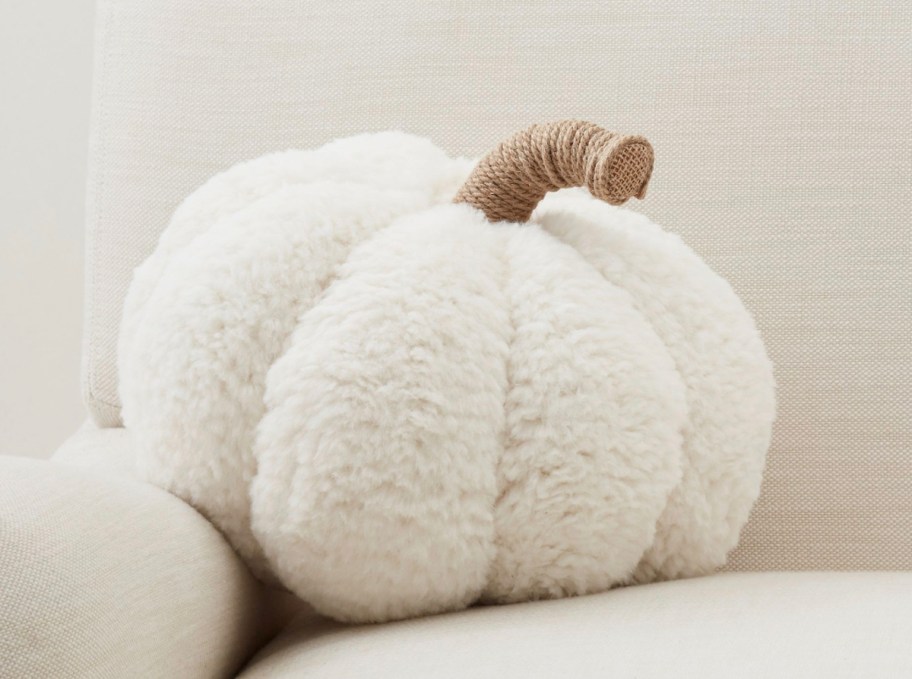 cozy sherpa white pumpkin shaped pillow on beige sofa