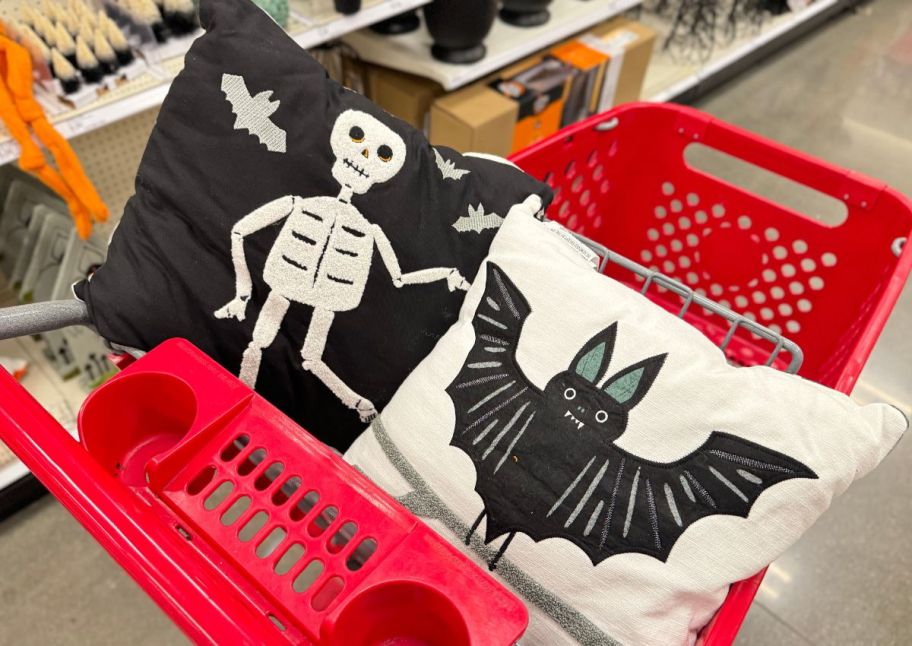 skeleton and bat halloween throw pillows arranged in a red target shopping cart