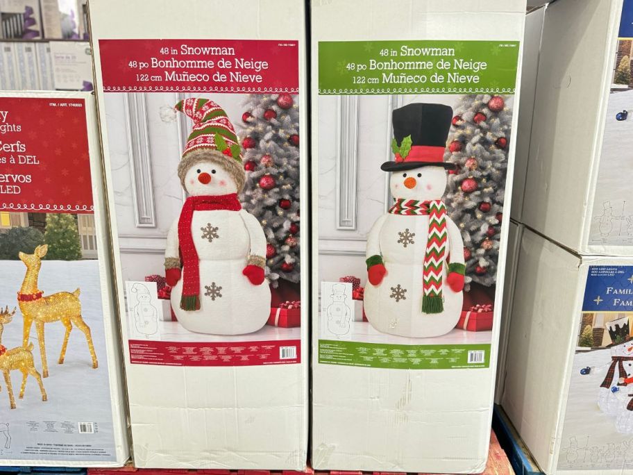 plush snowmen in boxes on display in a costco store