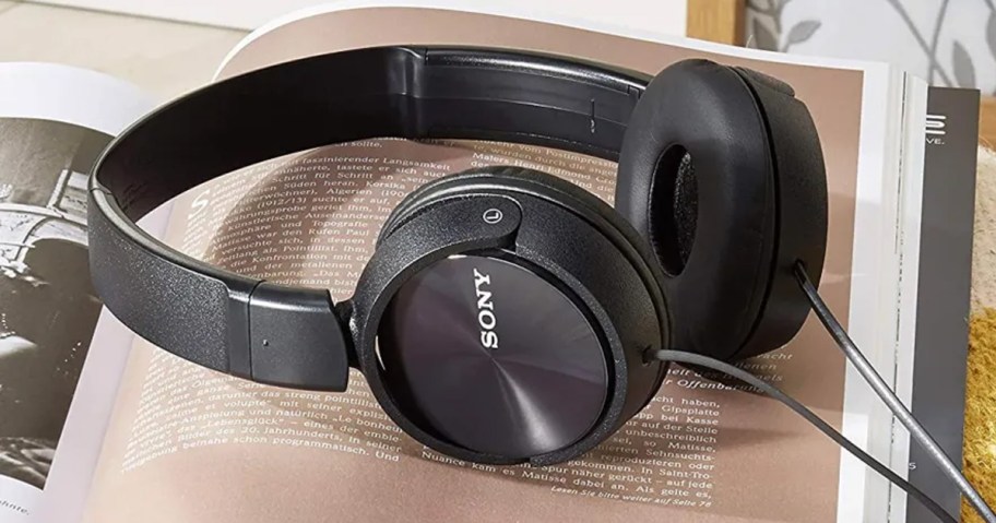 black sony headphones laying on open book