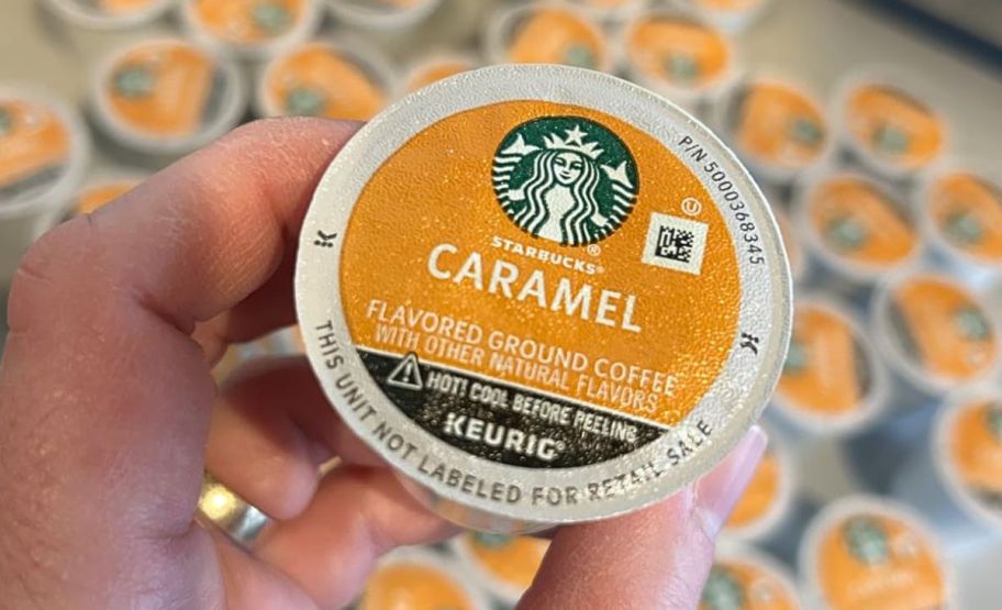 a hand holding a starbucks caramel k-cup pod