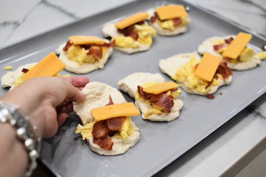 stuffing grands biscuits on a sheet pan 