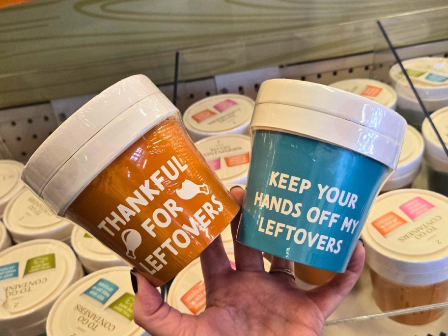 hand holding 2 sets of Thanksgiving themed to go containers with funny quotes on them