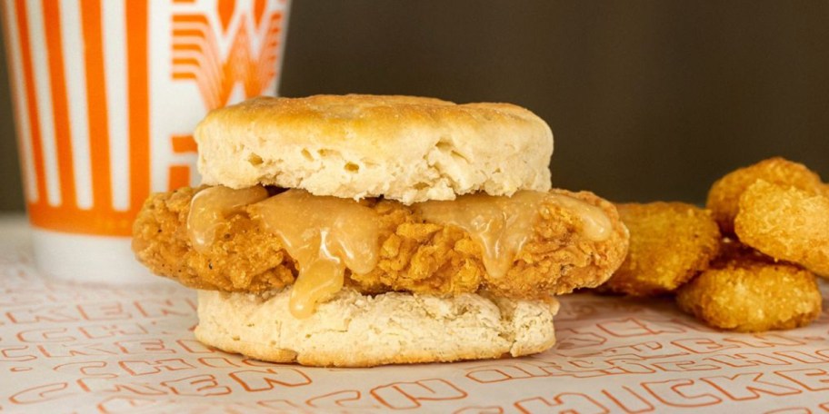 chicken biscuit with hashbrowns next to it 